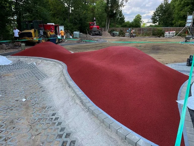 Ziegelrote Fallschutzfläche als Hügel modelliert, vor Ort gegossen